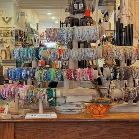 Display of handcrafted bracelets and jewelry arranged on wooden stands inside a boutique gift shop.
